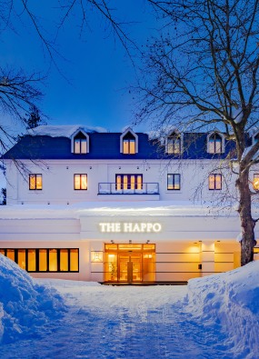 The exterior of the happo hotel at night in winter