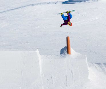 Snowboarder doing trick in the snowpark Snowboarder doing trick in the snowpark
