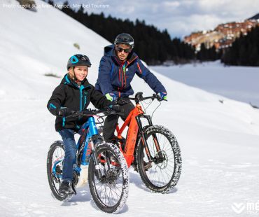 Father and son riding Fat Bikes through the snow Father and son riding Fat Bikes through the snow