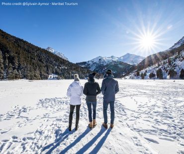 Three people walking in the snowy terrain Three people walking in the snowy terrain
